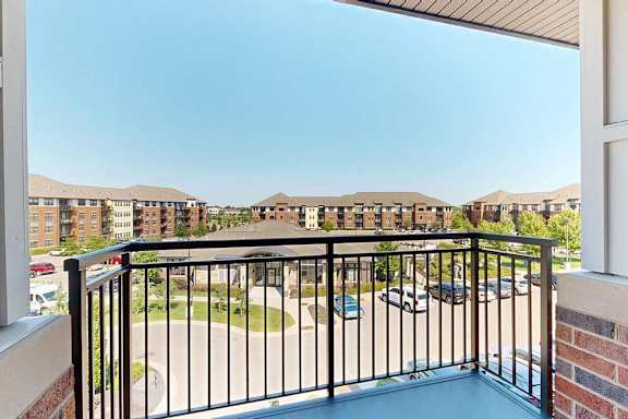 A balcony with a metal railing and a view of the community.