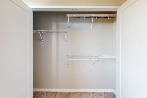 A double-door closet with built-in wire shelves in the second bedroom.