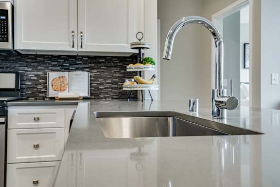 gray quartz counters and premium faucet in premium white finish apartment