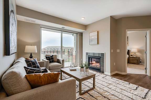 A living room with a couch, a coffee table, and a fireplace.