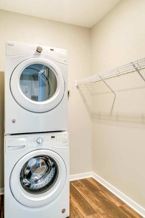 A stacked white washer and dryer in a laundry closet.