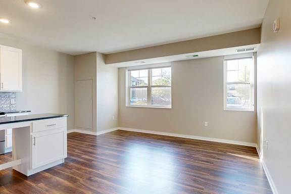 A living area with hardwood-style flooring and large windows for plenty of natural light.
