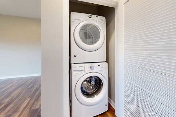 A stacked in-unit laundry washer and dryer in a closet.