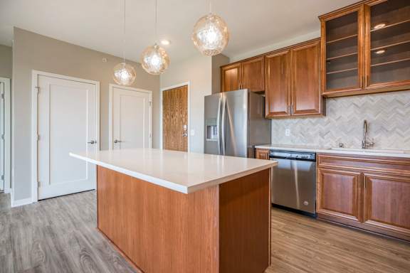 A kitchen with wooden cabinets and a white island.