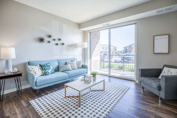 An apartment living room with a blue couch and a glass sliding door