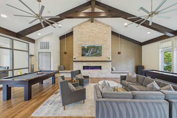 A living room with a pool table and a fireplace.