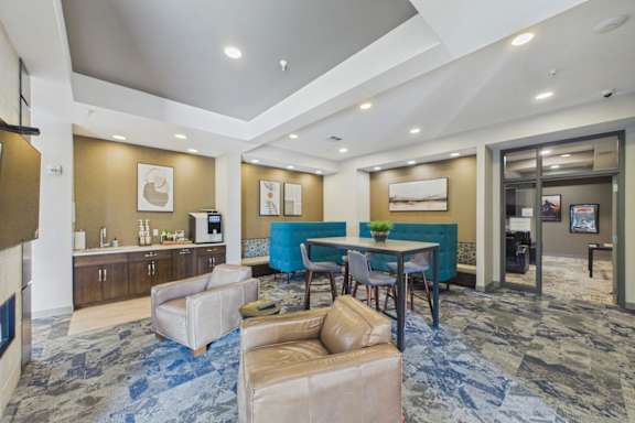 A spacious living room with a blue carpet and furniture.