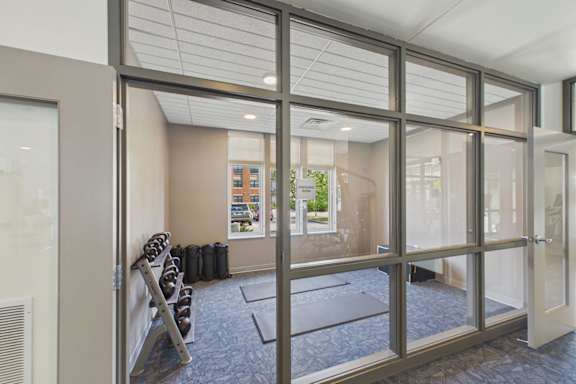 A room with a glass wall and a view of a building outside.