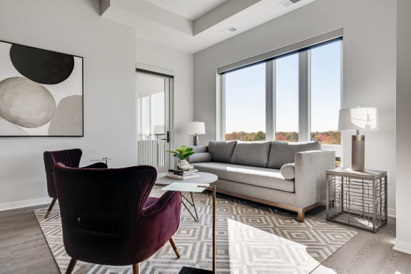 Furnished living room with high ceilings and large windows at Aspire at CityPlace Woodbury MN 55125