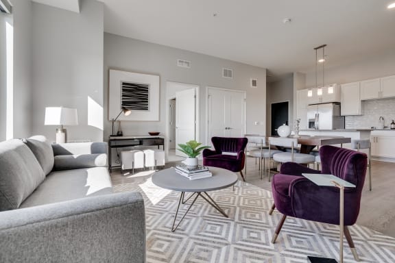 Furnished living room with high ceilings looking into the kitchen at Aspire at CityPlace Woodbury MN 55125