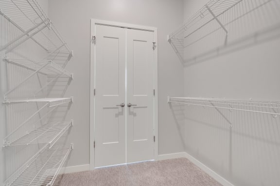 Large walk in closet with double doors and wire shelves on each side in 2 bedroom apartment in Woodbury MN 55125