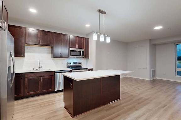 A kitchen with brown cabinets and a white counter.