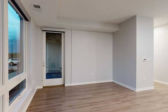 A room with a wooden floor and a sliding glass door.