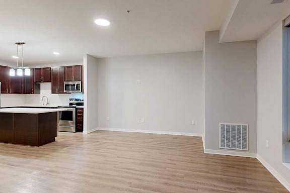 A spacious kitchen with dark wood cabinets and a white countertop.