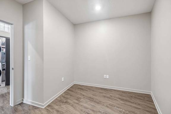Unfurnished den with wood-look flooring, recessed lighting, and a versatile layout suitable for a home office or study area.
