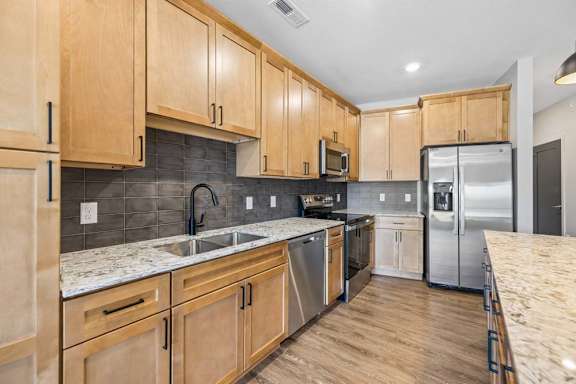 Modern kitchen featuring wood cabinets,quartz countertops, stainless steel appliances, and ample counter space for meal preparation.