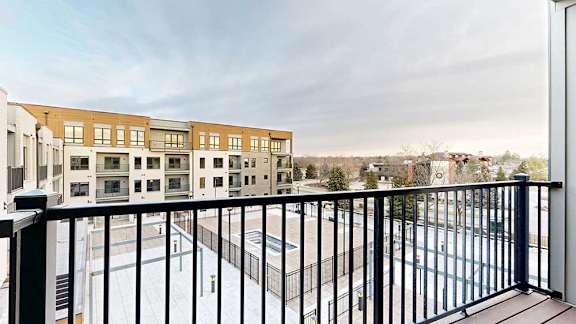 a balcony with a black metal railing and a view of the courtyard