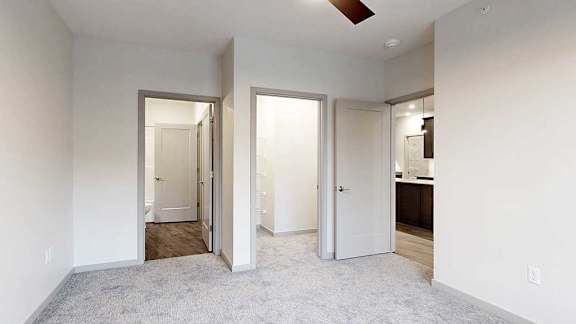 a bedroom with carpeted flooring, a walk-in shower, and a walk-through bathroom