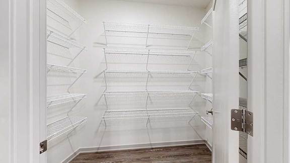 a large walk-in panty with several rows of built-in shelves