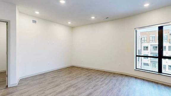 a living room with hardwood flooring and a large window