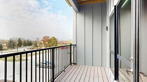 a balcony with a black metal railing and a window to the bedroom