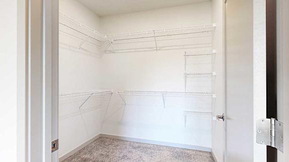 a walk-in closet with built-in shelving and hanging space on the far and left walls