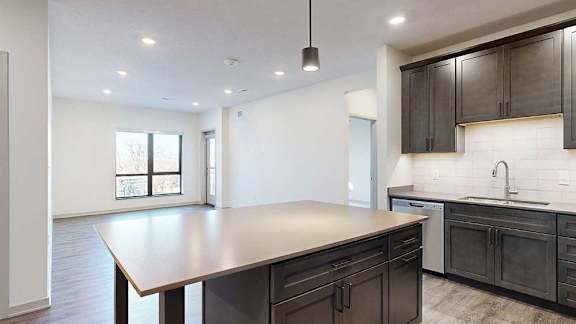 a modern kitchen with dark wood cabinets and a large central island