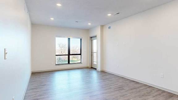 a spacious living room with a large window to bring in plenty of natural light