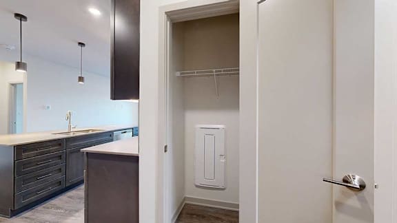A hallway coat closet with a wire shelf.