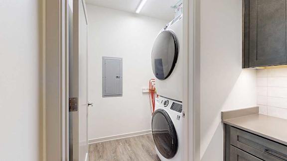 A stacked full-sized washer and dryer in a laundry room.