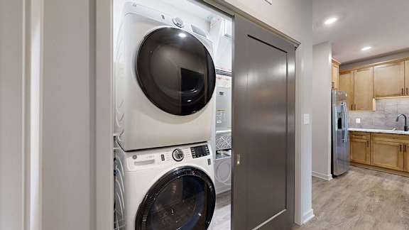 In-home apartment laundry closet with a stacked washer and dryer, conveniently located just off the kitchen.