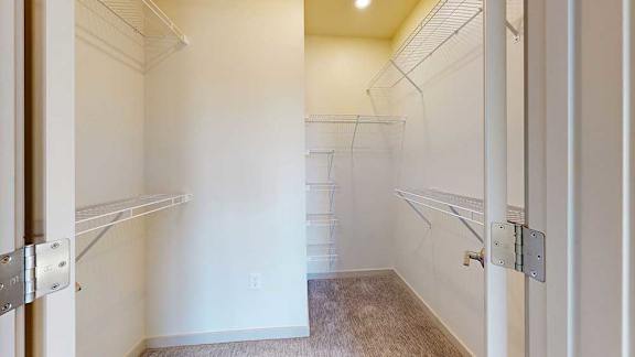 An oversized walk-in closet with several built-in wire shelves.