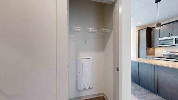 A hallway coat closet with a wire shelf.