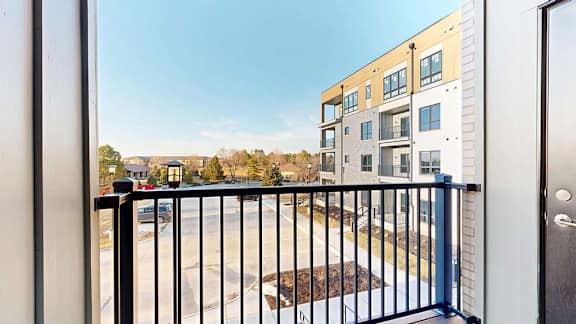 Private apartment balcony with views of the community and neighboring residential buildings.