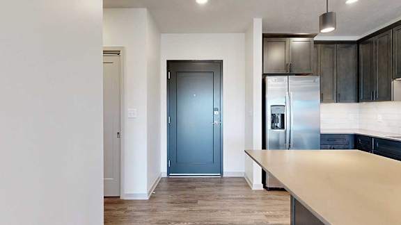 a dark grey front door next to a modern kitchen