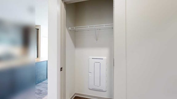 a coat closet with a built-in shelf in the front entryway