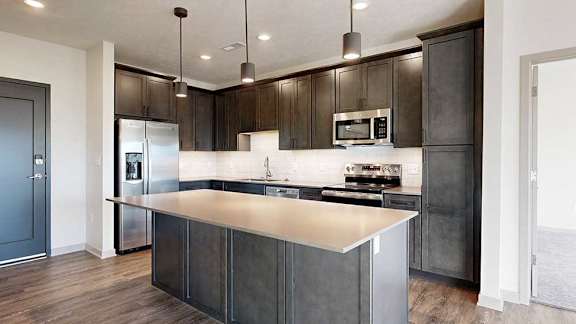 a modern kitchen with dark wood cabinets and stainless steel appliances