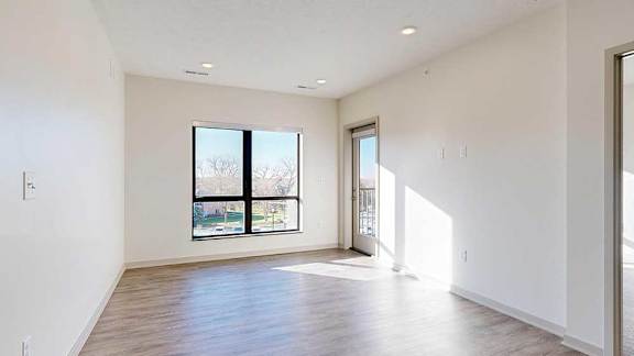a living room with a window and hardwood flooring