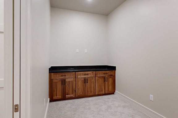 A carpeted den space with a built-in cabinet.