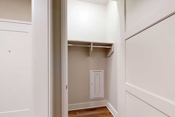 A coat closet in the entryway with a built-in shelf.
