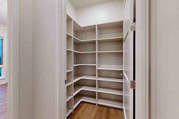 A walk-in pantry with built-in wooden shelves.