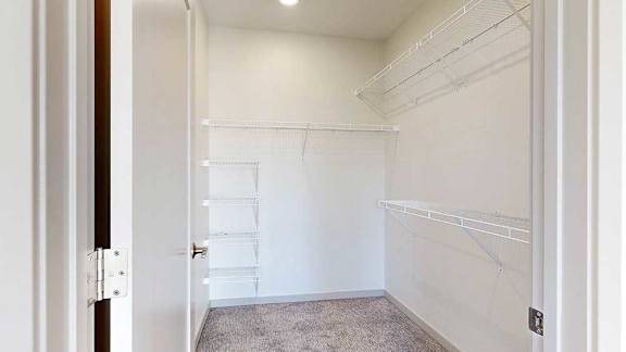 a walk in closet with built-in shelving and hanging space