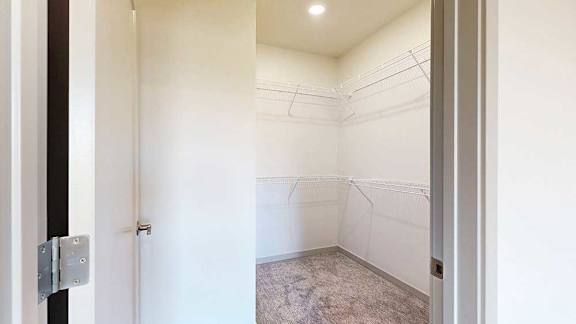 a walk in closet with built in shelving and hanging space