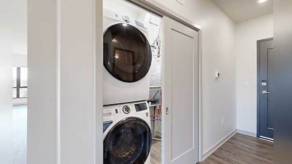 a laundry room with a full-sized stacked washer and dryer
