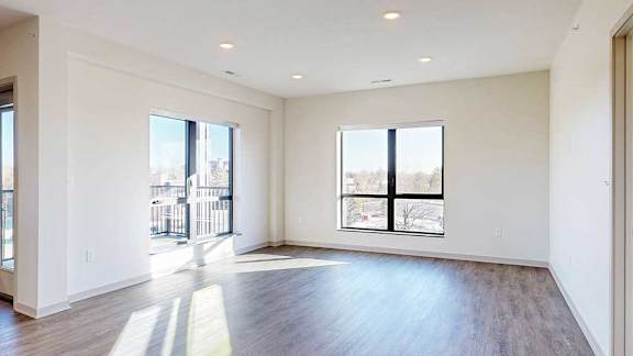 a living room with two large windows for plenty of natural light, and hardwood flooring