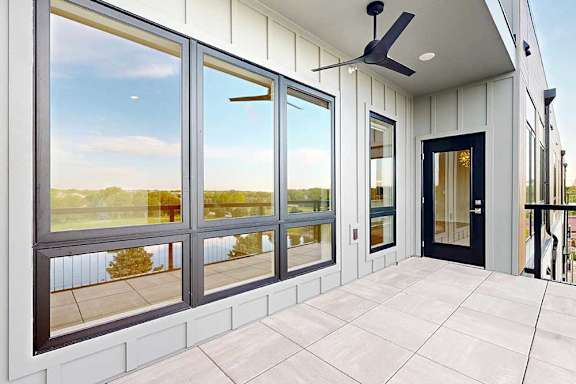 Large balcony with paved tile surface and ceiling fan
