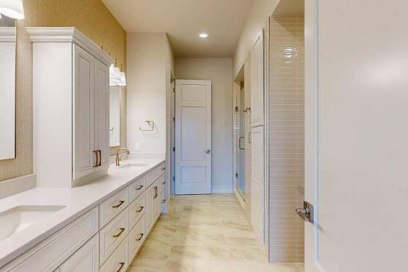 Primary bathroom with upscale finishes and dual vanities