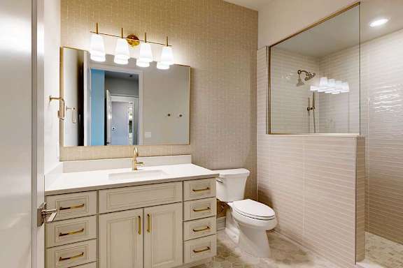 Penthouse apartment bathroom with white vanity and titled walk-in shower