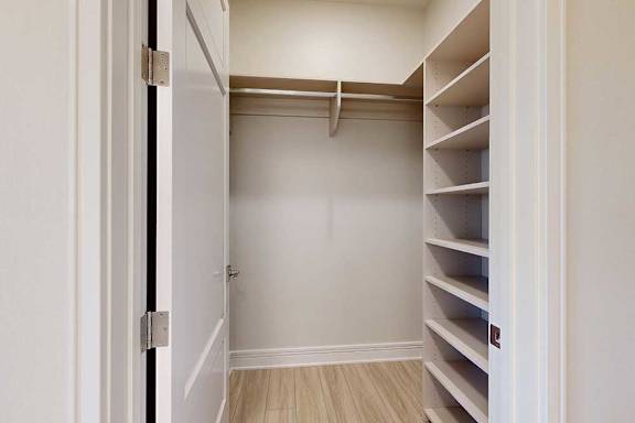 A white closet with built-in shelves and a door.