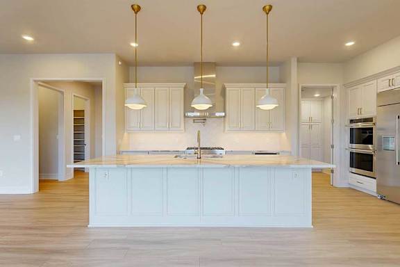 A kitchen with white cabinets and a large island.